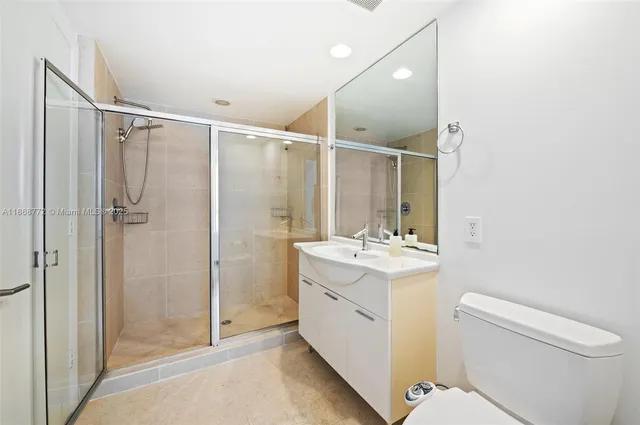 a bathroom with a granite countertop sink toilet and shower