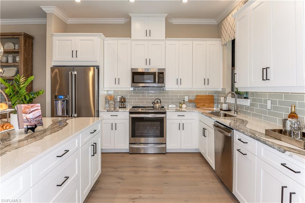 15336 Lucerna Street, Unit 203 Naples, FL 34114 - Photo 6 of 15 a kitchen with granite countertop a sink stove and refrigerator