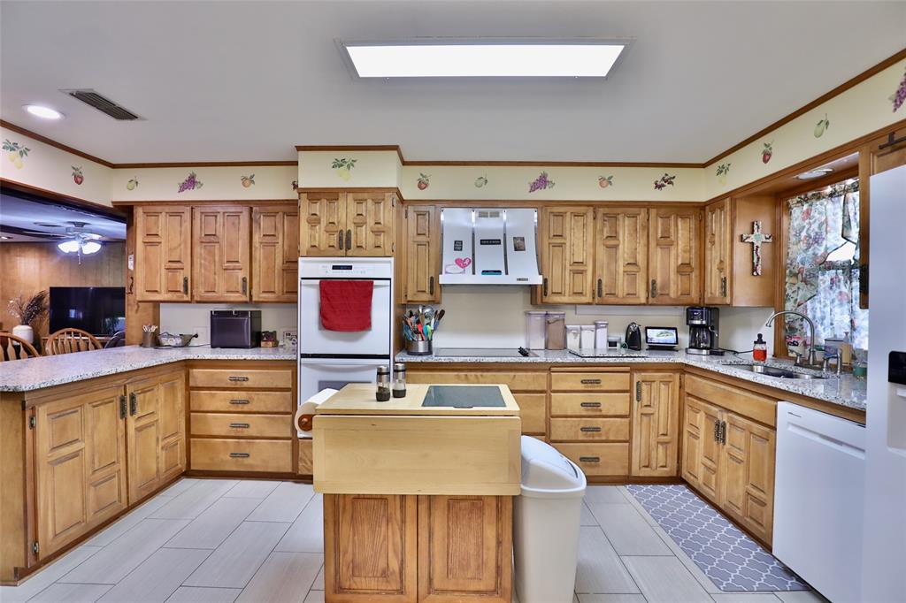 448 Elmdale Road South Abilene, TX 79602 - Photo 12 of 39 a kitchen with a stove a sink a refrigerator and cabinets