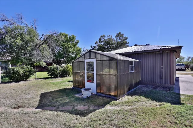 a view of a small house with wooden fence