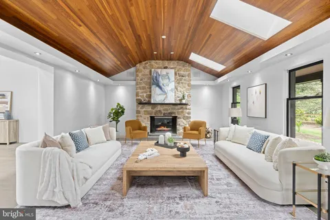 a living room with furniture a fireplace and a large window