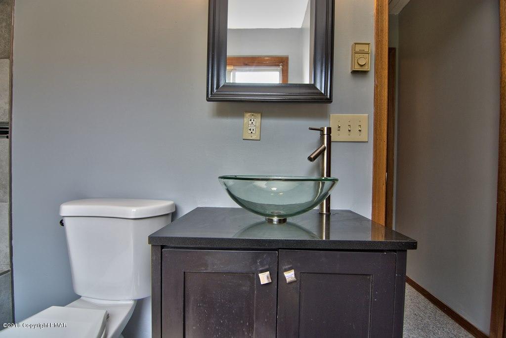 4112 Blueberry Hill Road Bushkill, PA 18324 - Photo 29 of 39 a bathroom with a toilet a sink and mirror