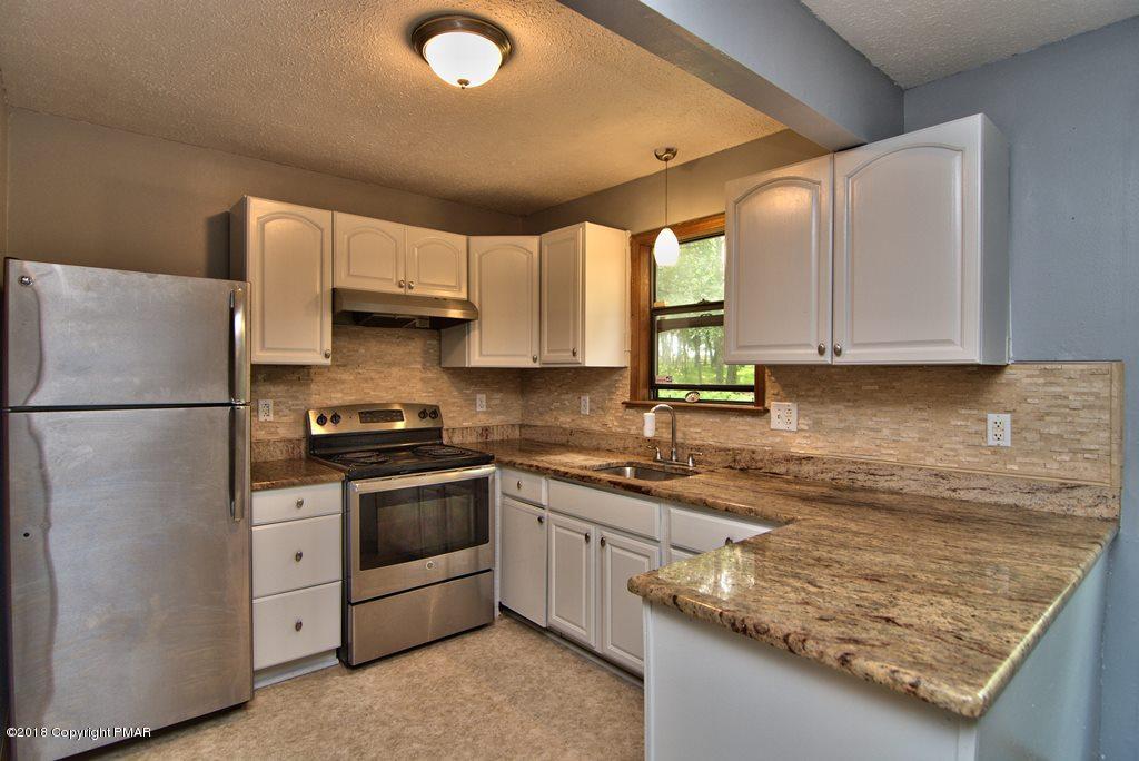 4112 Blueberry Hill Road Bushkill, PA 18324 - Photo 10 of 39 a kitchen with stainless steel appliances granite countertop a sink stove and refrigerator