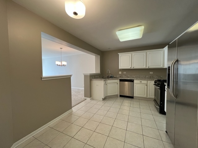 Undisclosed Address Naperville, IL 60564 - Photo 7 of 26 a kitchen with a sink a refrigerator and cabinets