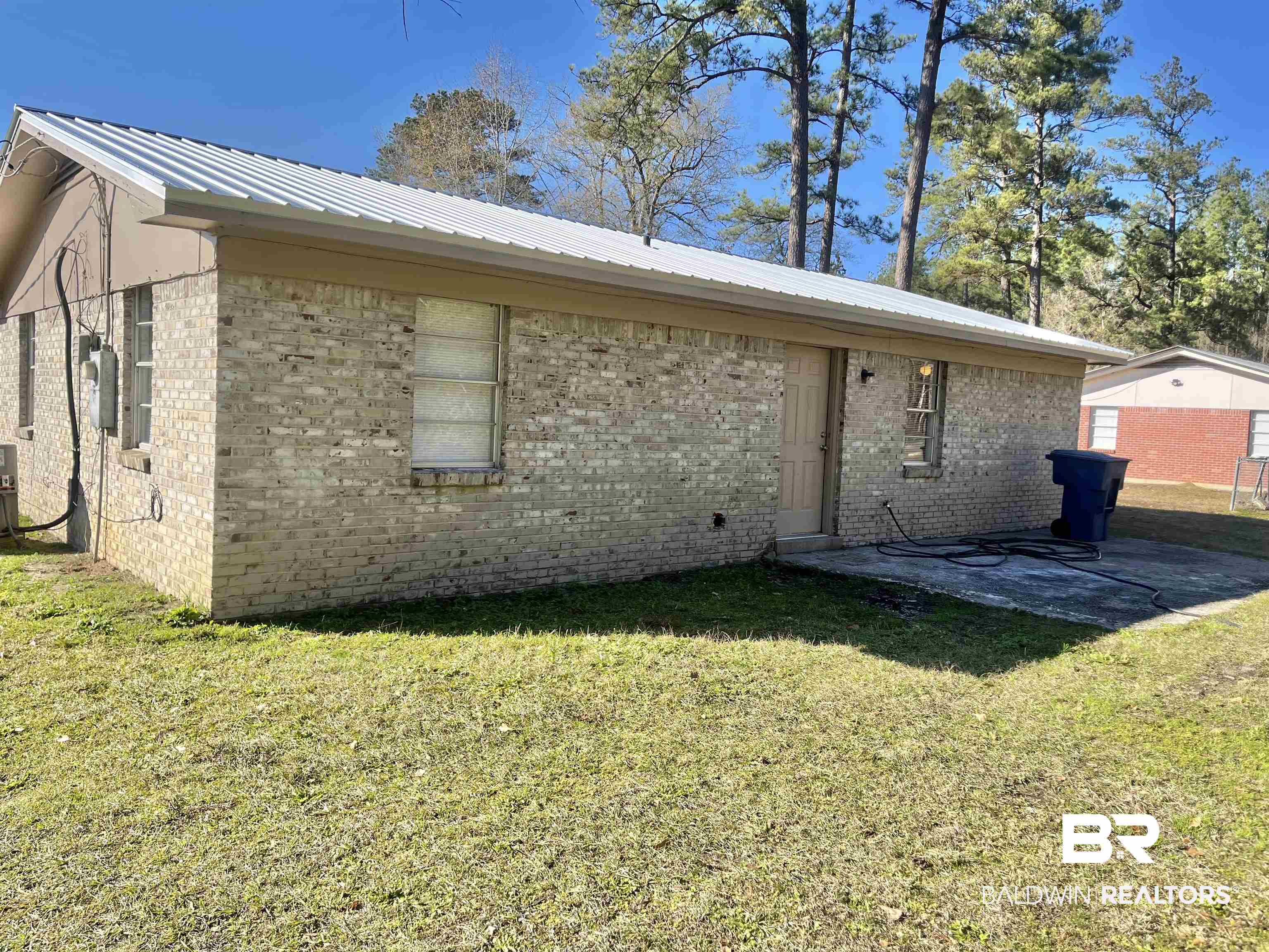 103 Roadway Street Brewton, AL 36426 - Photo 5 of 13 Rear view of house with a lawn and a patio area