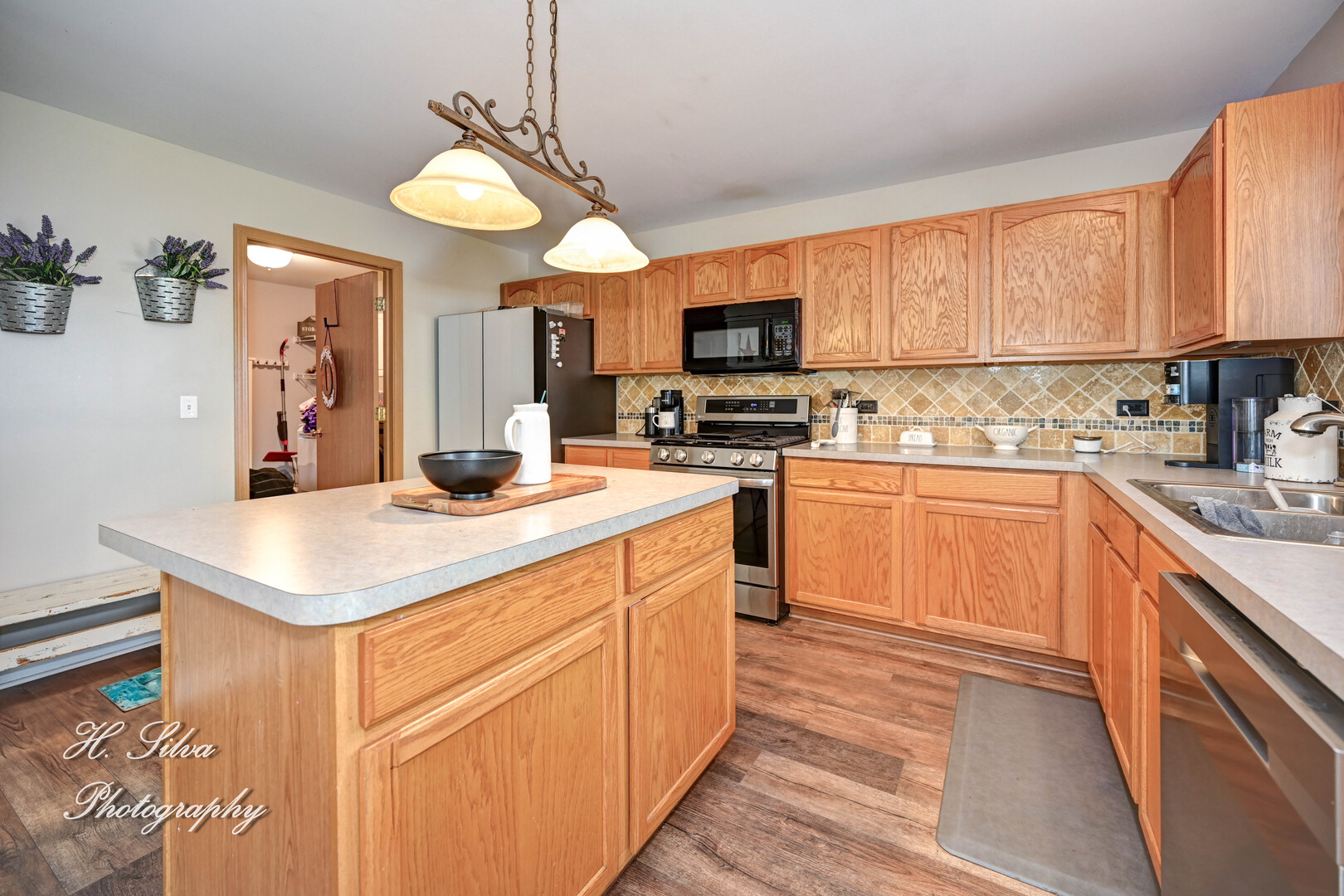 602 Spring Drive Marengo, IL 60152 - Photo 6 of 25 a kitchen with a stove top oven a sink dishwasher and a refrigerator with wooden floor
