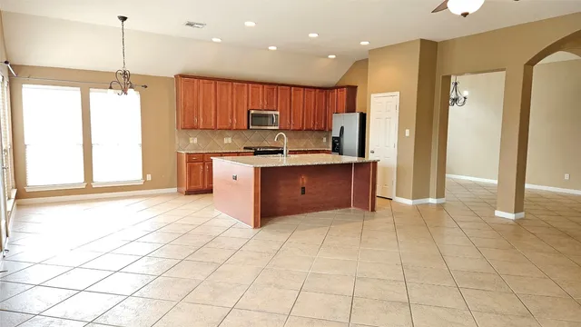 a large kitchen with stainless steel appliances granite countertop a stove a sink and a refrigerator