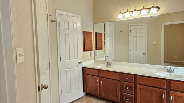 a bathroom with double vanity sinks and a mirror