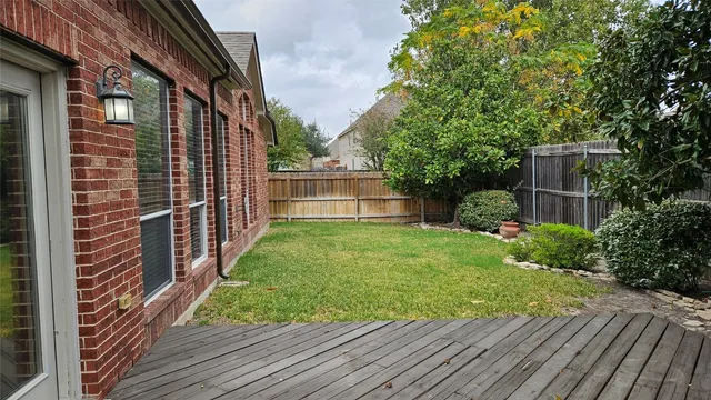 a view of a backyard with potted plants and large tree