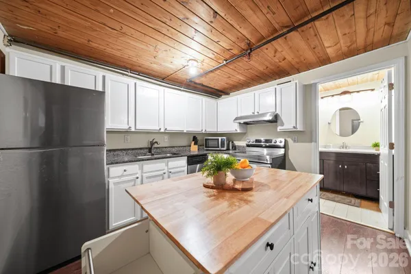 a kitchen with a refrigerator a stove a sink and cabinets
