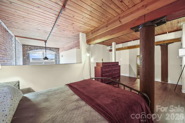 a bedroom with a bed closet and wooden floor