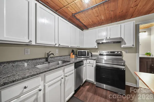 a kitchen with stainless steel appliances granite countertop a sink a stove and cabinets