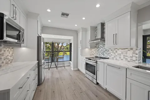 a kitchen with stainless steel appliances kitchen island granite countertop a stove a sink and a microwave