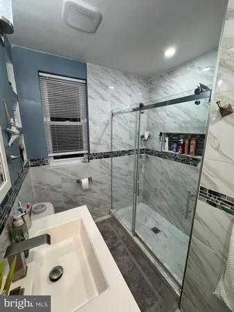 a bathroom with a sink mirror and shower