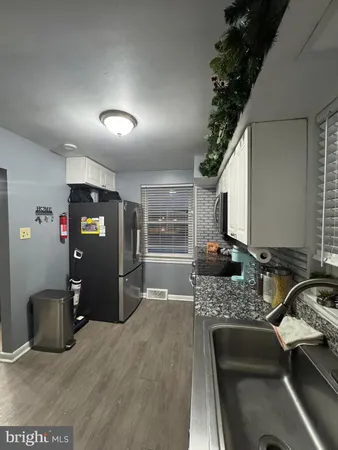a kitchen with granite countertop a refrigerator stove and sink