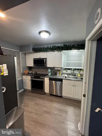 a kitchen with granite countertop a stove a sink dishwasher and cabinets