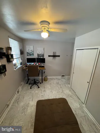 a view of a workspace with furniture and a window