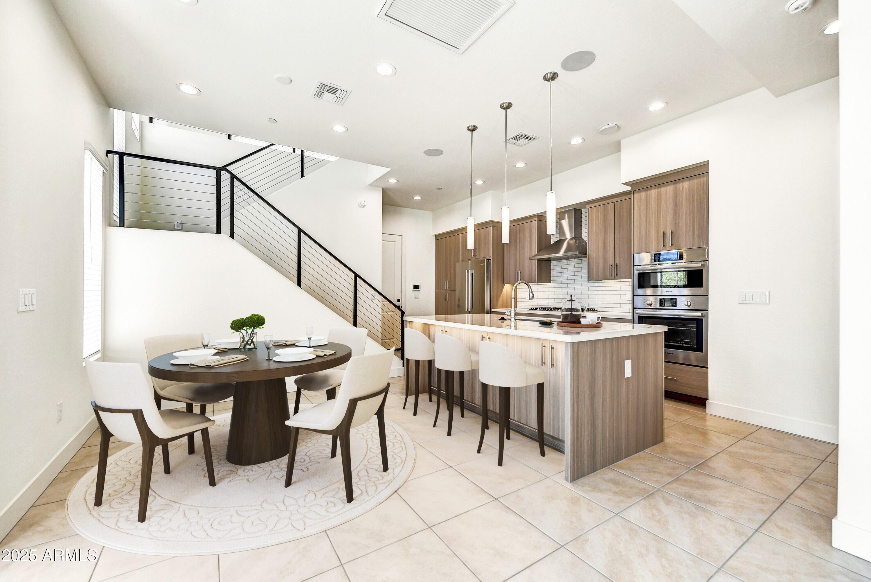 1 Easy Street, Unit 12 Carefree, AZ 85377 - Photo 5 of 43 a kitchen with stainless steel appliances kitchen island granite countertop a table chairs and a refrigerator