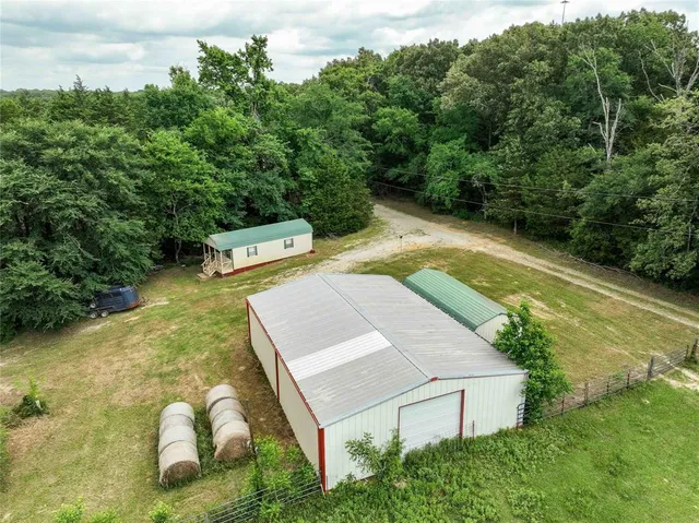 an aerial view of residential houses with outdoor space and trees