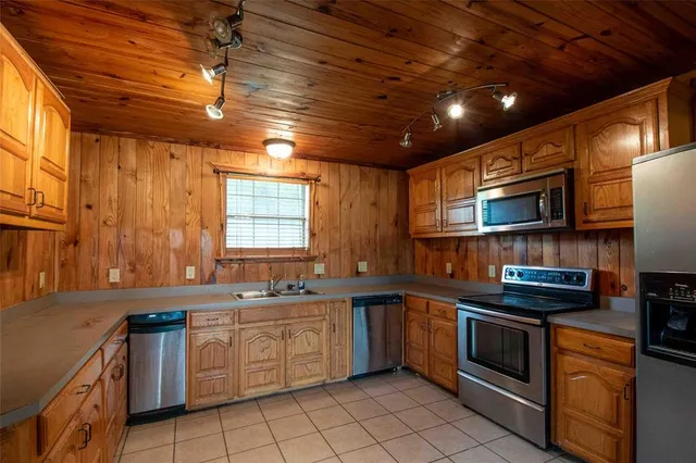 a kitchen with stainless steel appliances granite countertop a sink a stove and cabinets