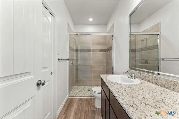 a bathroom with a granite countertop sink a shower and a mirror