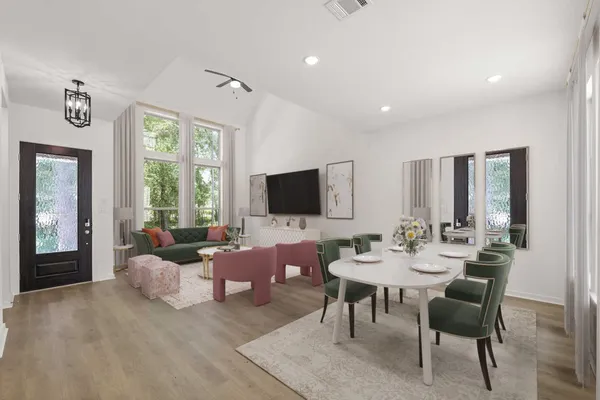 a living room with furniture flat screen tv and a large window