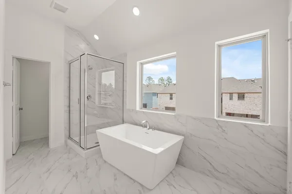 a bathroom with a tub sink shower and mirror