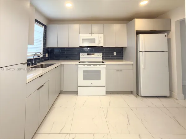 a kitchen with cabinets stainless steel appliances and a sink