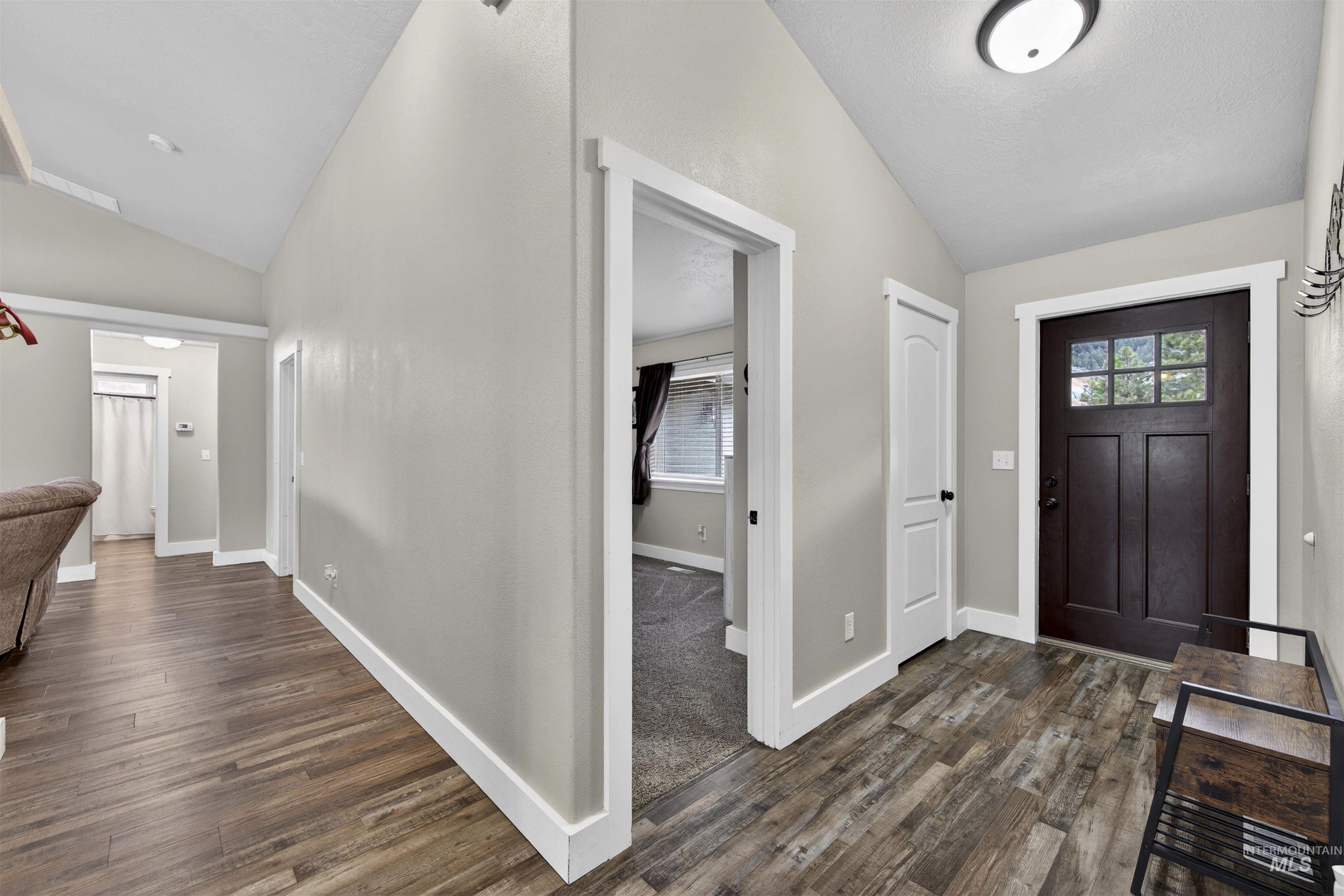 4 Round Up Circle Boise, ID 83716 - Photo 35 of 47 Entryway featuring wood-finish flooring, a dark wood-paneled door with multi-pane window, and vaulted ceilings