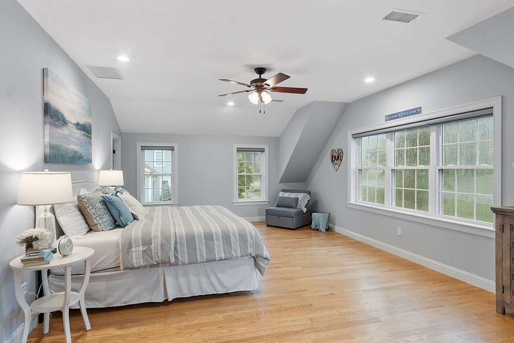 64 Mill Pond Road Bolton, MA 01740 - Photo 21 of 41 a spacious bedroom with a large bed and a chandelier
