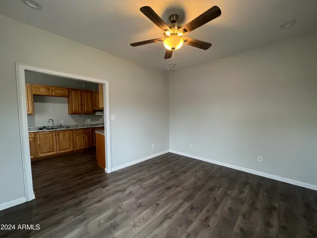 a view of an empty room with window and wooden floor