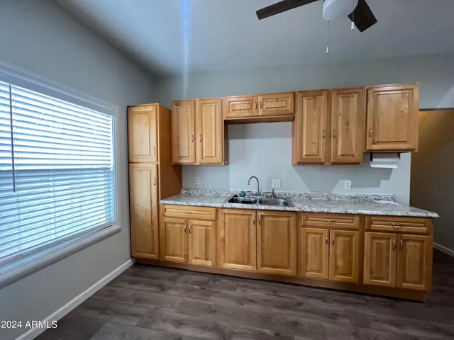 a kitchen with granite countertop wooden cabinets a sink and dishwasher