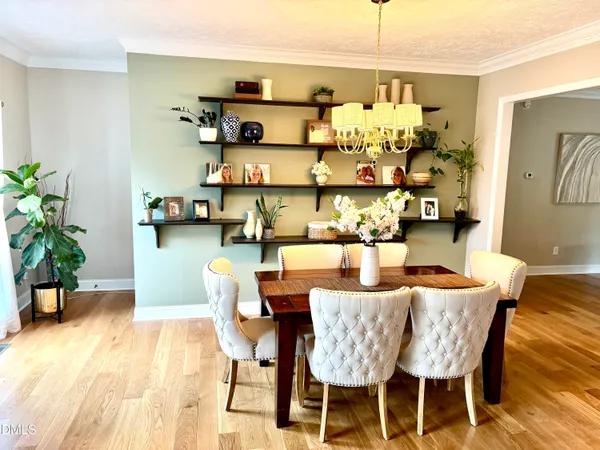 a view of a dining room and livingroom with furniture a rug a fireplace and wooden floor