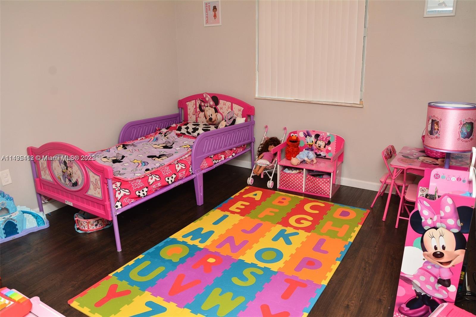 1990 Southwest 103rd Terrace Miramar, FL 33025 - Photo 17 of 19 a bedroom with a bed and wooden floor