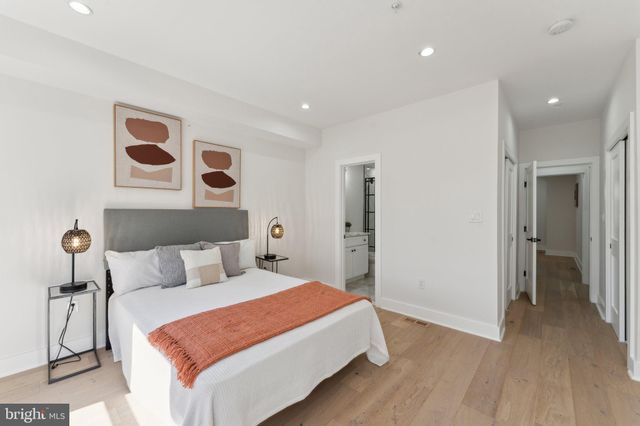 a bedroom with a large bed and painting on the wall