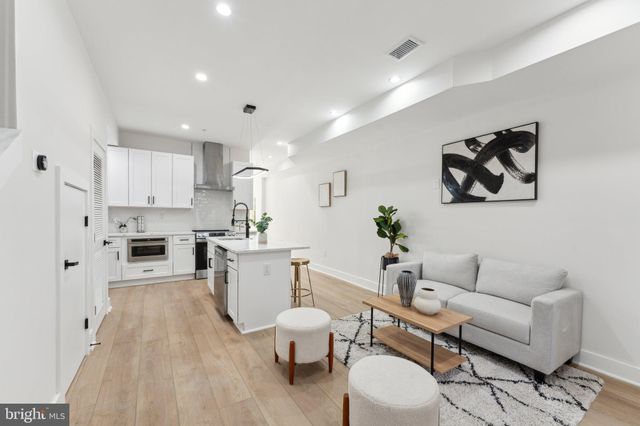 a living room with furniture and a kitchen