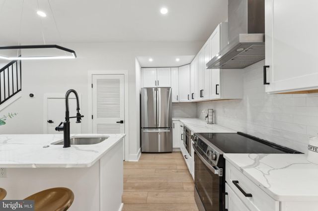 a kitchen with a sink a stove a refrigerator and a cabinets