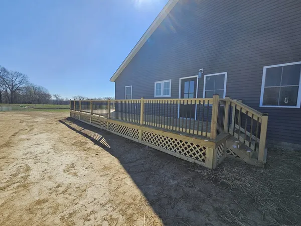 a view of balcony with wooden floor and fence