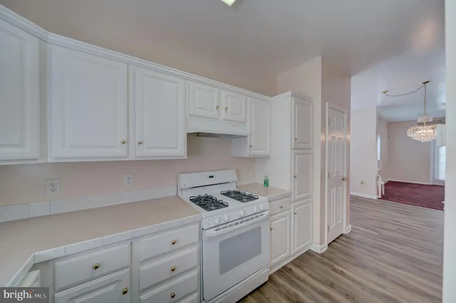 a kitchen with granite countertop white cabinets and white appliances