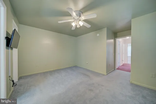 an empty room with a ceiling fan and a window