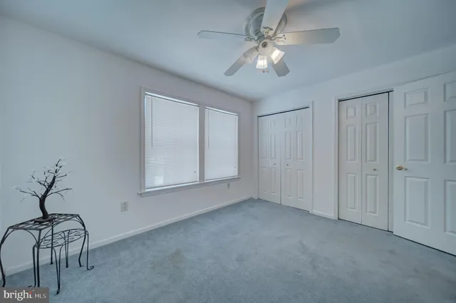 a view of an empty room with chandelier fan