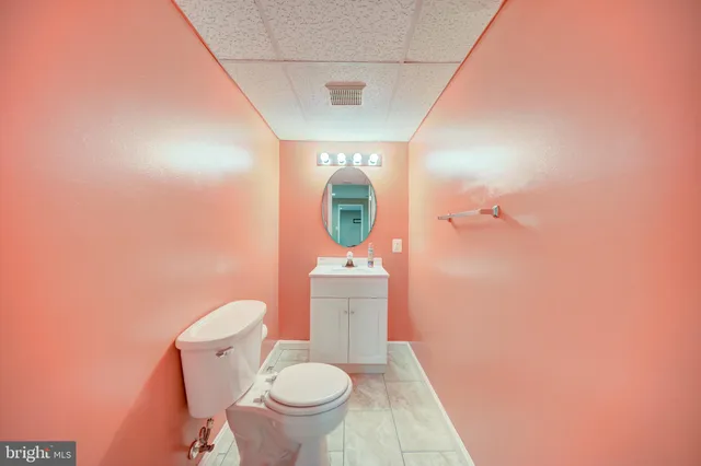 a bathroom with a granite countertop toilet and a sink