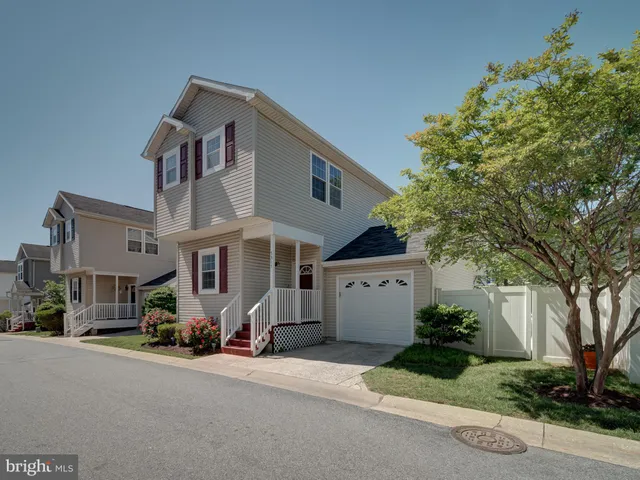 a front view of a house with a garden and trees