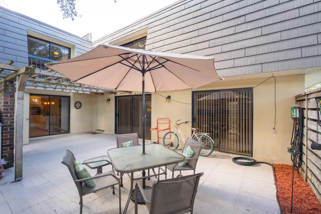a patio with a table and chairs under an umbrella