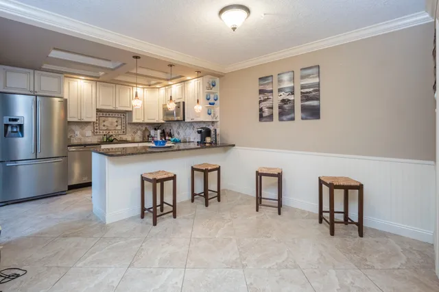 a kitchen with cabinets and chairs