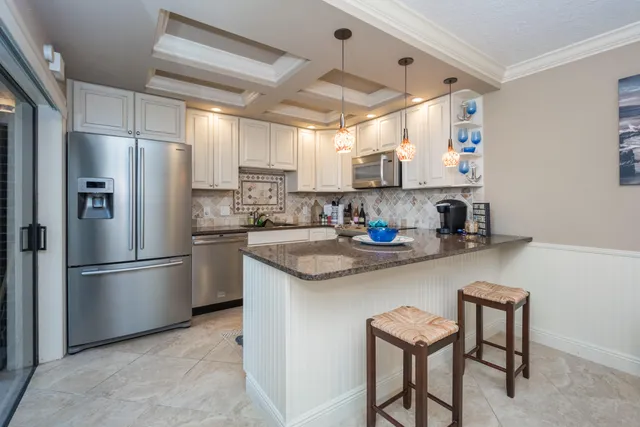 a kitchen with stainless steel appliances granite countertop a sink and a refrigerator