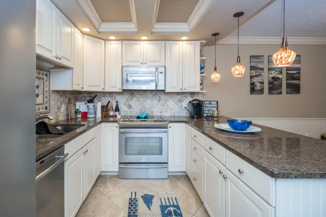 a kitchen with stainless steel appliances granite countertop a sink a stove and cabinets
