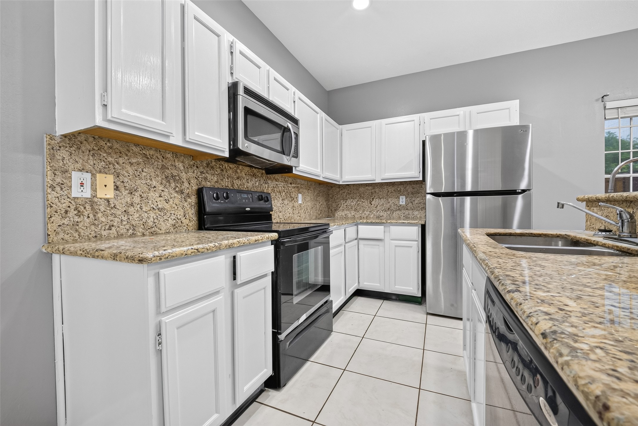 13607 Sable Lane Houston, TX 77014 - Photo 15 of 46 a kitchen with granite countertop a sink stove and cabinets