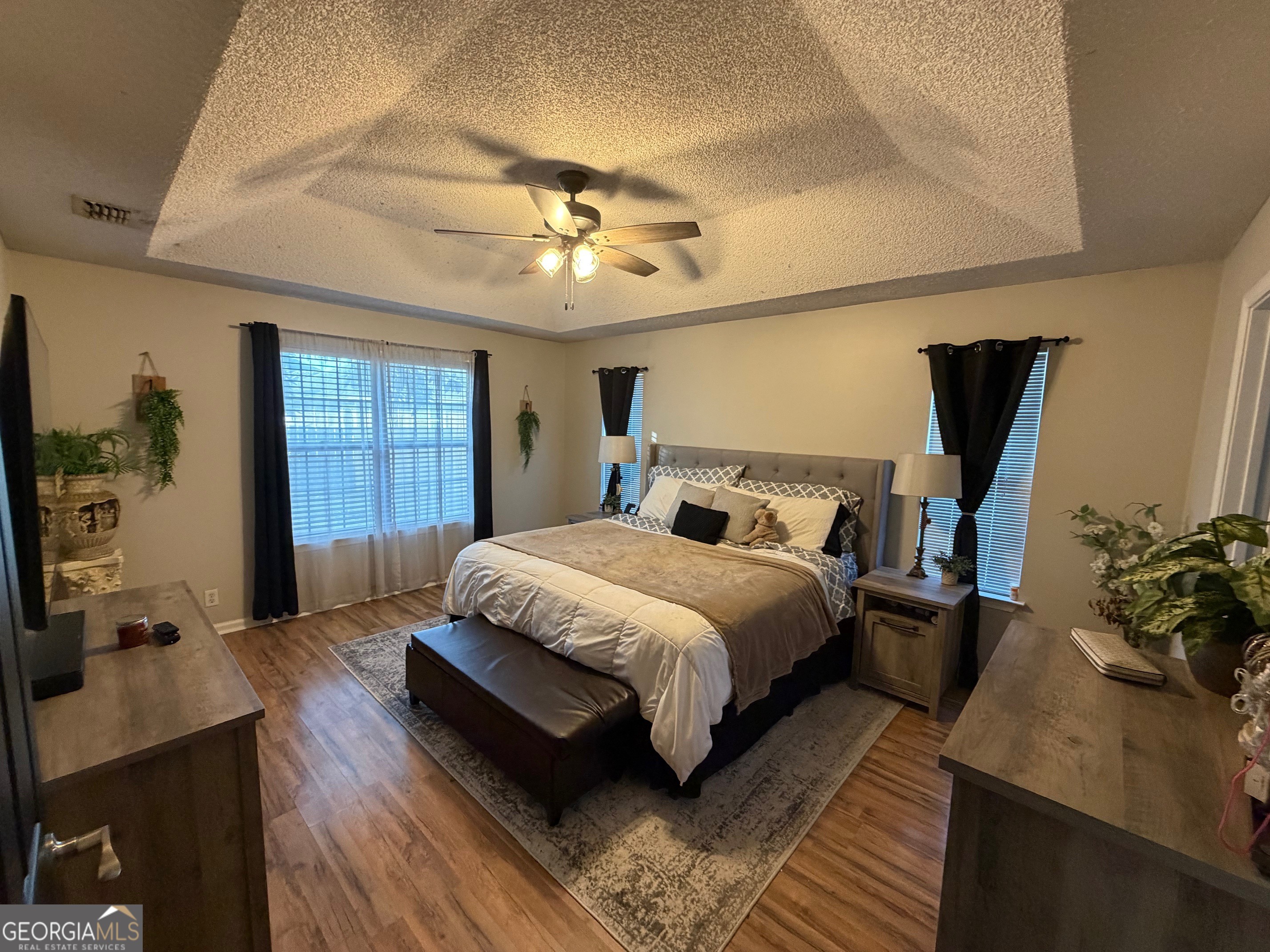 202 Bent Tree Court St. Marys, GA 31558 - Photo 14 of 25 a bedroom with a bed a dresser and potted plants with the wooden floor