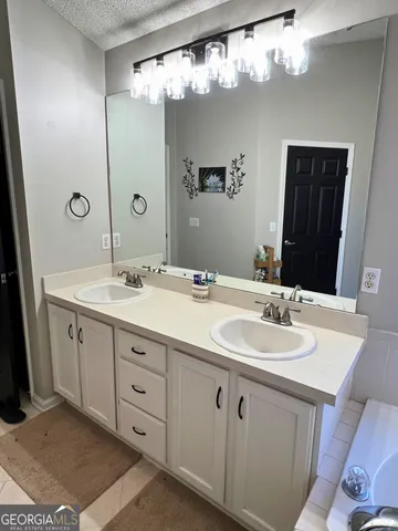 a bathroom with a double vanity sink and a mirror